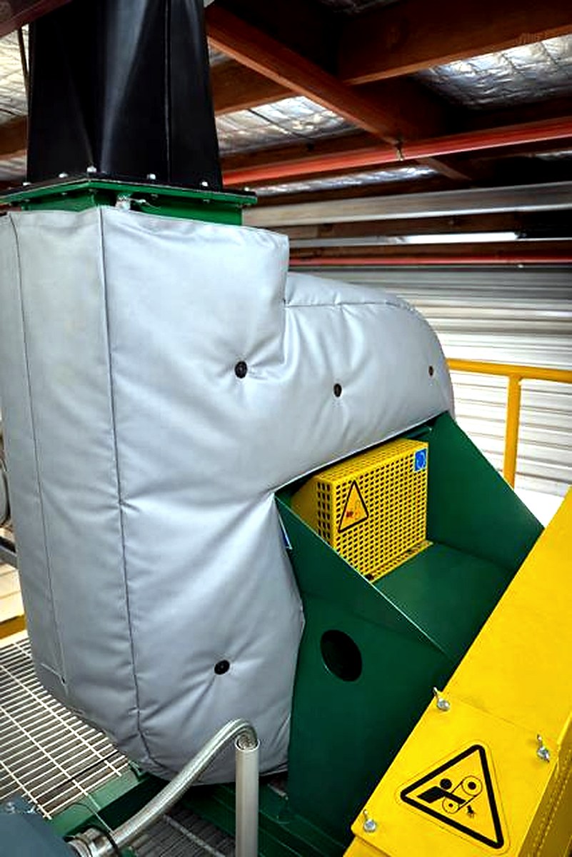 Plant room corridor with overhead clad pipework and thermal jackets on lower-level connections